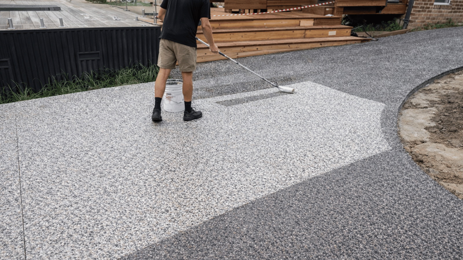 Professional owner inspecting and preparing driveway for sealing